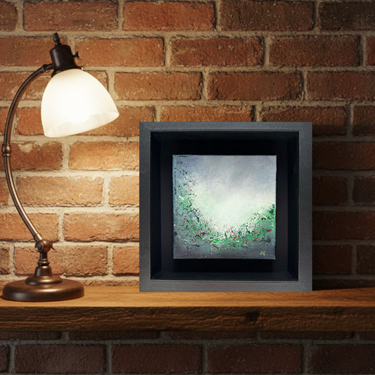 Through the Green Haze abstract art by Sinéad Guilfoyle styled as shelf decor next to a warm glowing lamp demonstrating the piece's intimate scale and tactile surface.