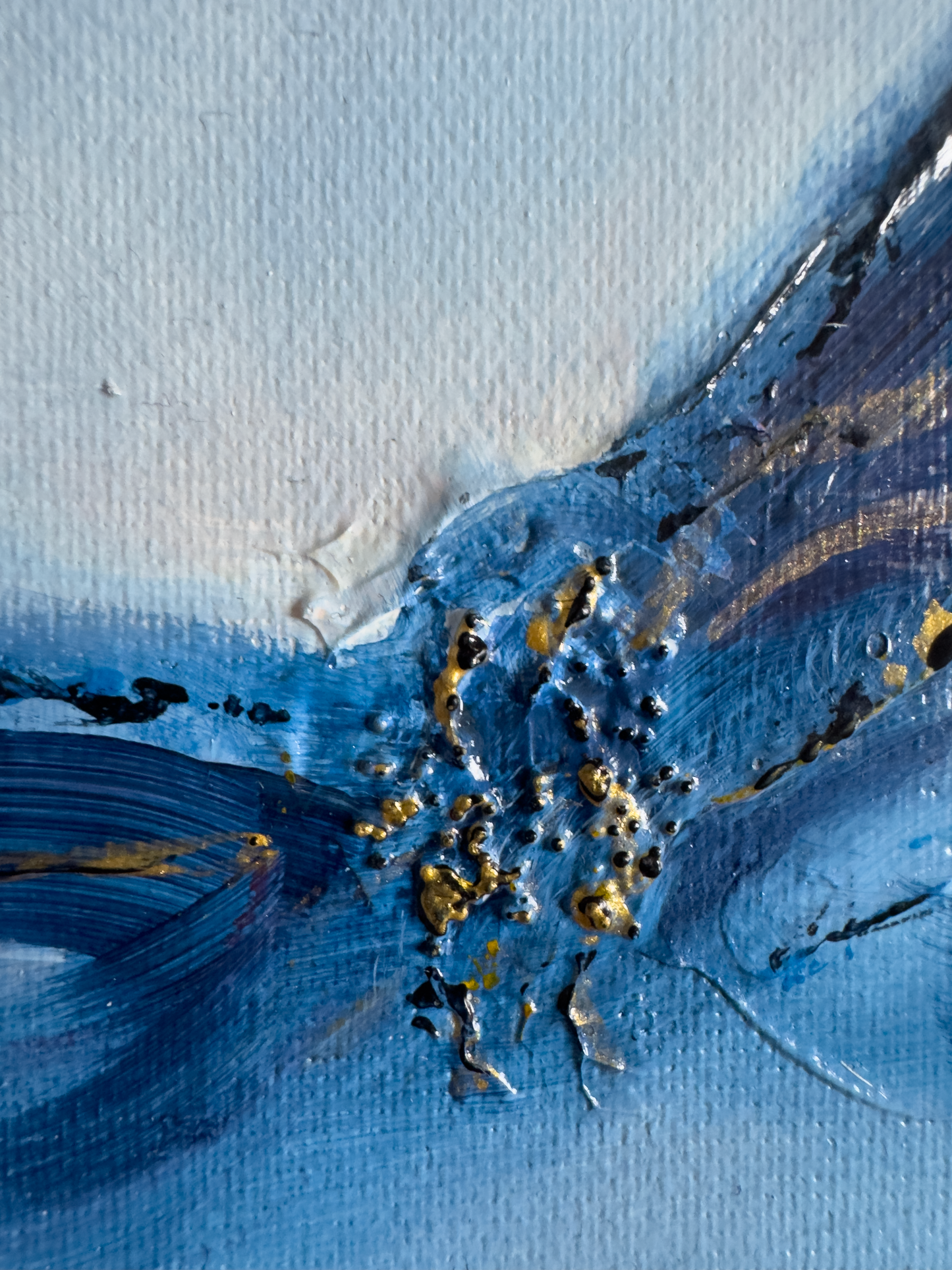 Extreme close-up of Emergence 1 showing heavy impasto paint texture, raised gold leaf fragments, and fine canvas grain in shades of cerulean and navy blue.